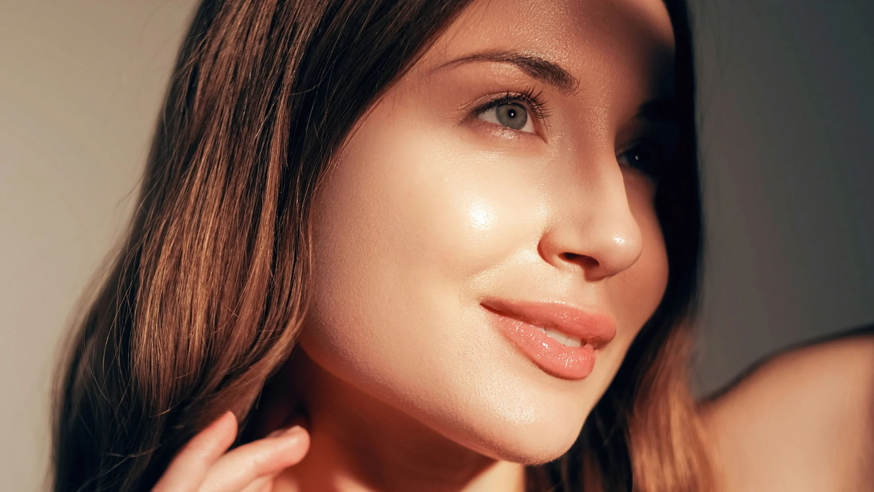 Close-up of a woman with glowing, radiant skin, looking confident and refreshed in soft natural lighting